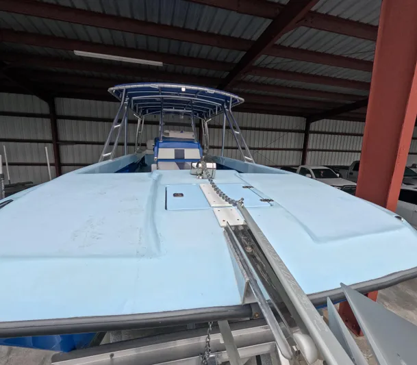 Cool Change Yacht Photos Pics 2022 Eastward 30 boat in storage, featuring a light blue deck and canopy.