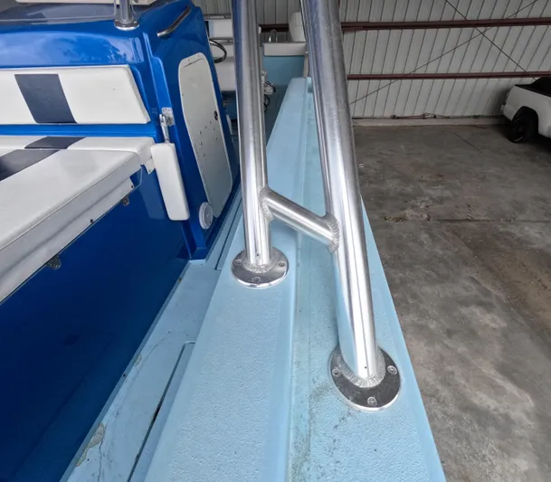 Cool Change Yacht Photos Pics 2022 Eastward 30 boat interior with blue and white seating, metal railings, and storage compartment.