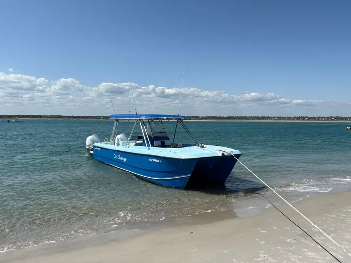 Cool Change Yacht Photos Pics Blue Eastward 30 boat anchored on sandy beach, clear sky, calm water, 2022 model.