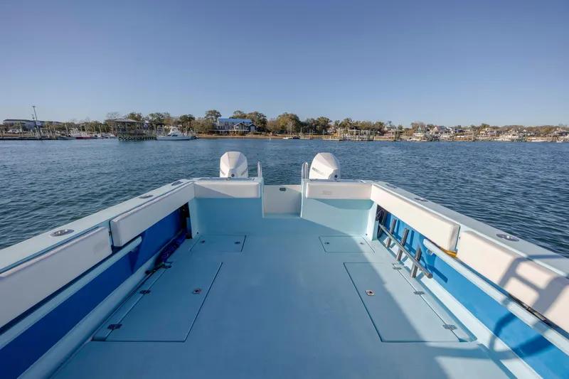 Cool Change Yacht Photos Pics 2022 Eastward 30 boat on calm water, spacious deck, scenic shoreline view.