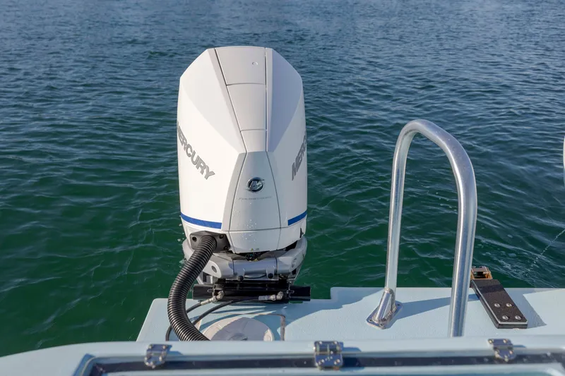 Cool Change Yacht Photos Pics Outboard motor on 2022 Eastward 30 boat, with railing, on calm water.