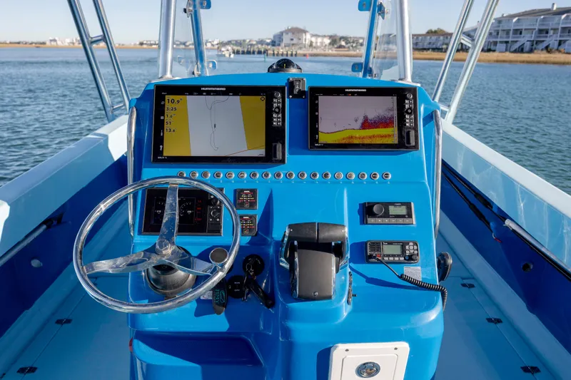Cool Change Yacht Photos Pics Control panel of 2022 Eastward 30 boat with navigation screens and steering wheel.