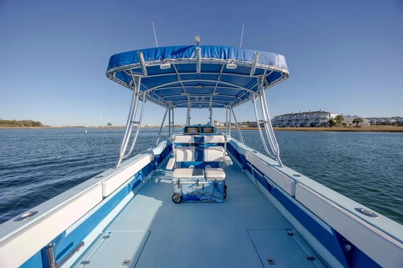 Cool Change Yacht Photos Pics 2022 Eastward 30 boat with blue canopy on calm water, clear sky background.