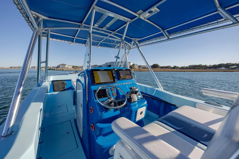 Cool Change Yacht Photos Pics Interior view of 2022 Eastward 30 boat with blue seating and navigation equipment.