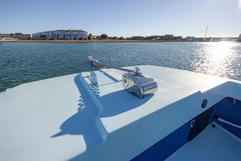 Cool Change Yacht Photos Pics Bow of 2022 Eastward 30 boat with anchor, overlooking serene water and distant shoreline.