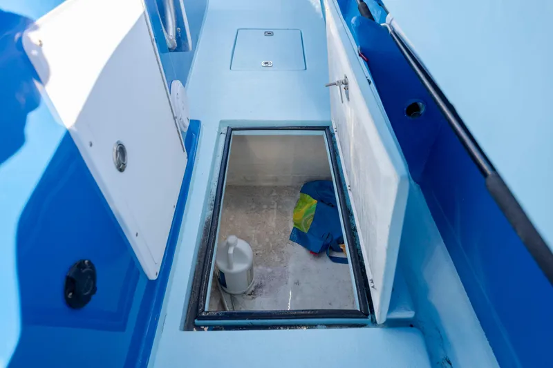 Cool Change Yacht Photos Pics Open storage compartment on 2022 Eastward 30 boat, featuring blue interior and white hatch.