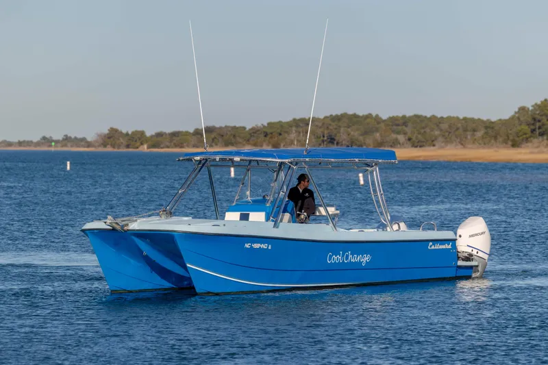 Cool Change Yacht Photos Pics Blue 2022 Eastward 30 boat named "Cool Change" on calm water with trees in background.