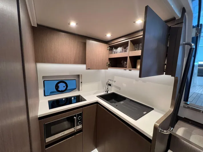 Sealine S390 Yacht Photos Pics Modern kitchen interior of 2022 Sealine S390 yacht with sleek cabinetry and appliances.