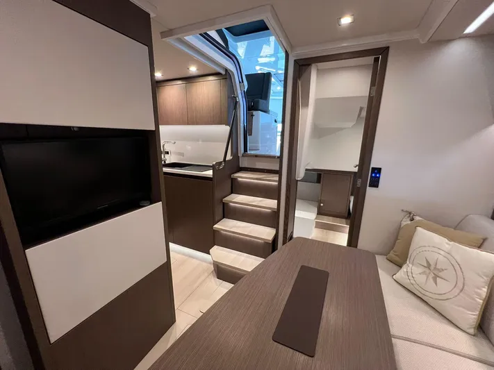 Sealine S390 Yacht Photos Pics Interior of 2022 Sealine S390 yacht, featuring modern kitchen, stairs, and cozy seating area.