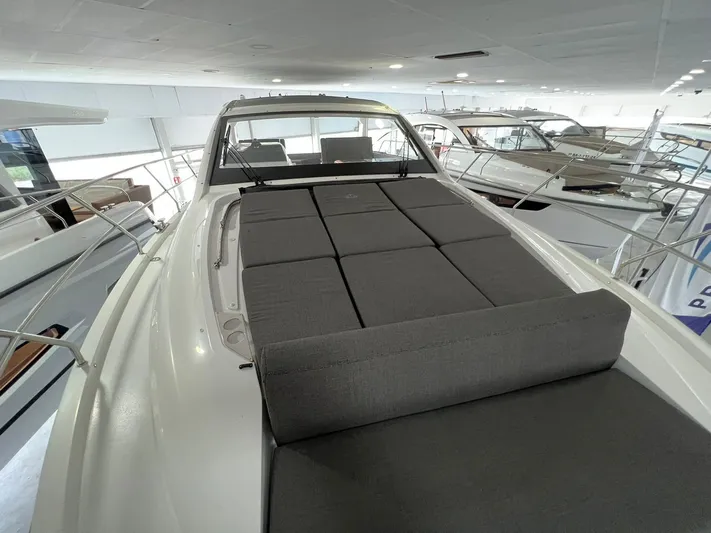 Sealine S390 Yacht Photos Pics 2022 Sealine S390 yacht with spacious sunbed on deck, showcased indoors.