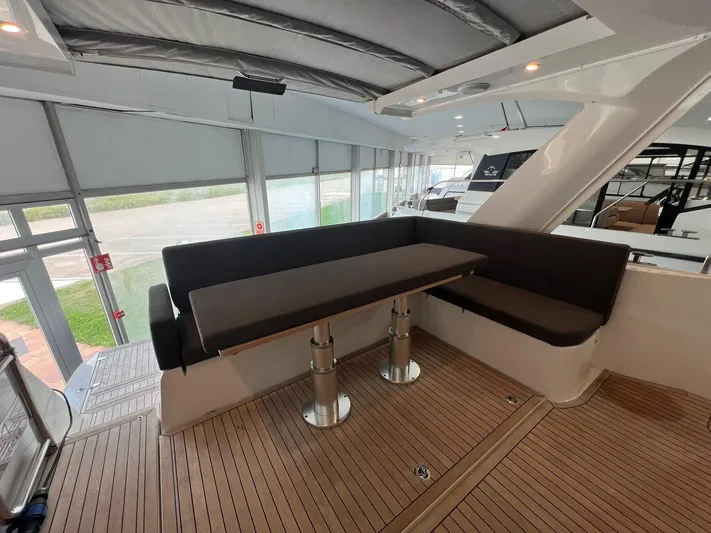 Sealine S390 Yacht Photos Pics Interior of 2022 Sealine S390 yacht with modern seating and wooden flooring.