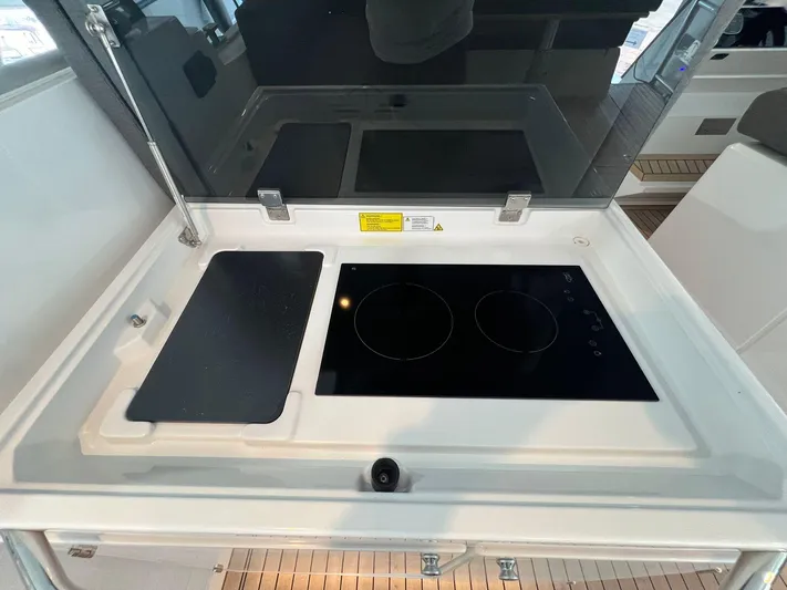 Sealine S390 Yacht Photos Pics Modern kitchen area on 2022 Sealine S390 yacht with sleek induction cooktop.