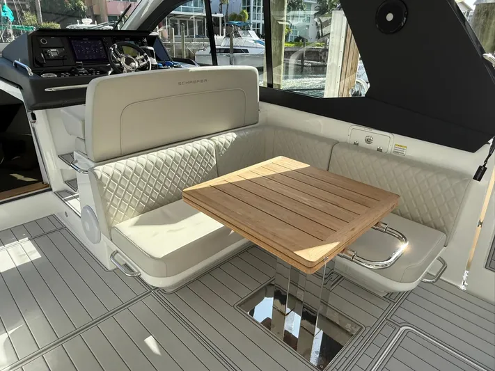Moana & Malie Yacht Photos Pics Luxurious 2025 Schaefer 375 yacht interior with elegant seating and wooden table.