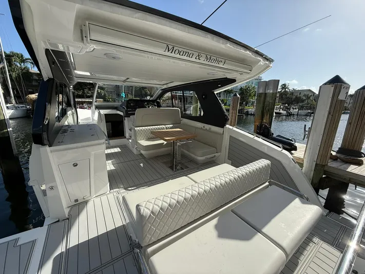 Moana & Malie Yacht Photos Pics Luxurious 2025 Schaefer 375 yacht interior with elegant seating and dining area at a marina.