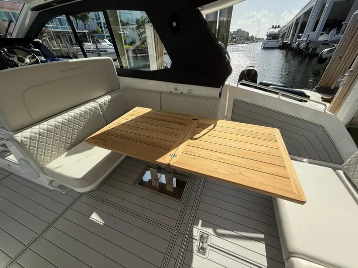 Moana & Malie Yacht Photos Pics Luxurious 2025 Schaefer 375 yacht interior with elegant seating and wooden table by the water.