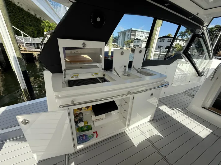 Moana & Malie Yacht Photos Pics Luxury yacht Schaefer 375 (2025) with outdoor kitchen and storage, docked by waterfront.