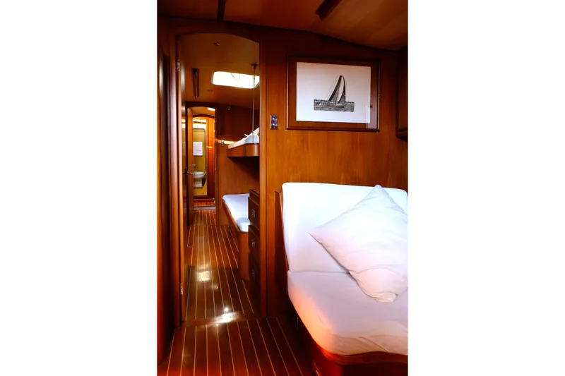 Matchless Yacht Photos Pics Interior of 1982 Chantier Naval de l&rsquo;Anitra RON HOLLAND 68 yacht, featuring wooden finishes and cozy bedding.