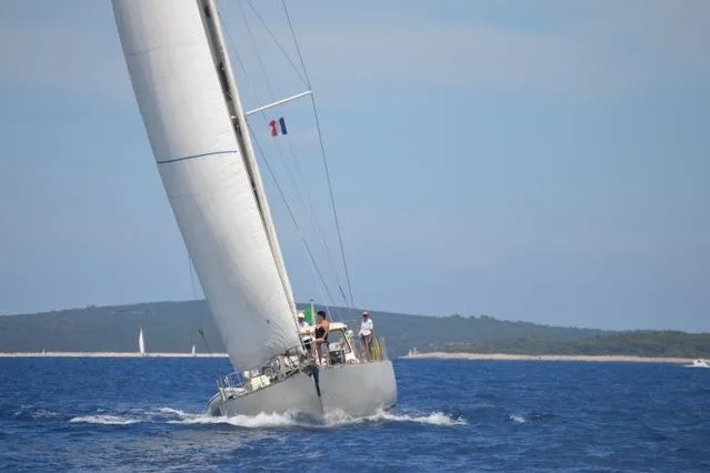 Matchless Yacht Photos Pics Sailing yacht "RON HOLLAND 68" from 1982 navigating blue waters, crew onboard.