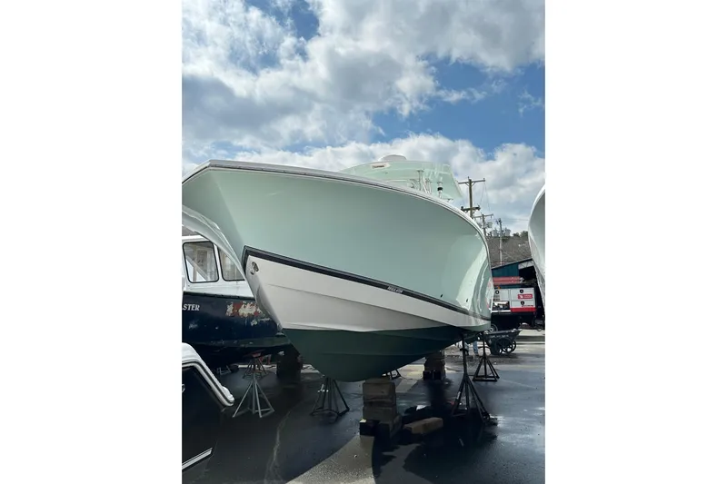 Asia Yacht Photos Pics 2005 Regulator 32 Forward Seating boat displayed outdoors under a cloudy sky.