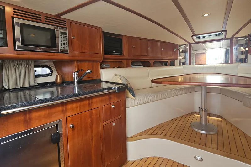 Taipan Yacht Photos Pics Luxurious 2006 Chris-Craft Corsair 36 interior with wood cabinetry and cozy seating area.