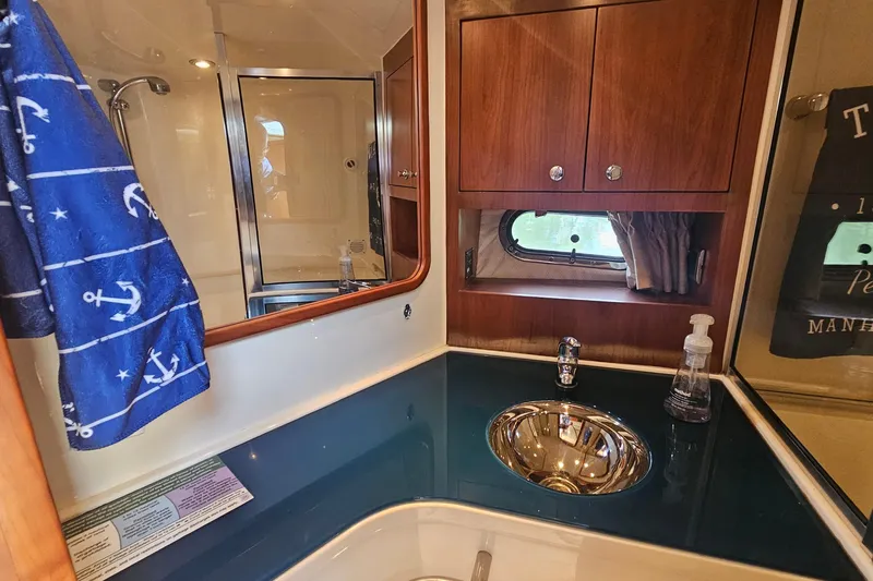 Taipan Yacht Photos Pics Luxurious bathroom in 2006 Chris-Craft Corsair 36 yacht with wood cabinets and nautical decor.