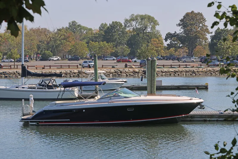Taipan Yacht Photos Pics 2006 Chris-Craft Corsair 36 docked at a marina, surrounded by trees and parked cars.