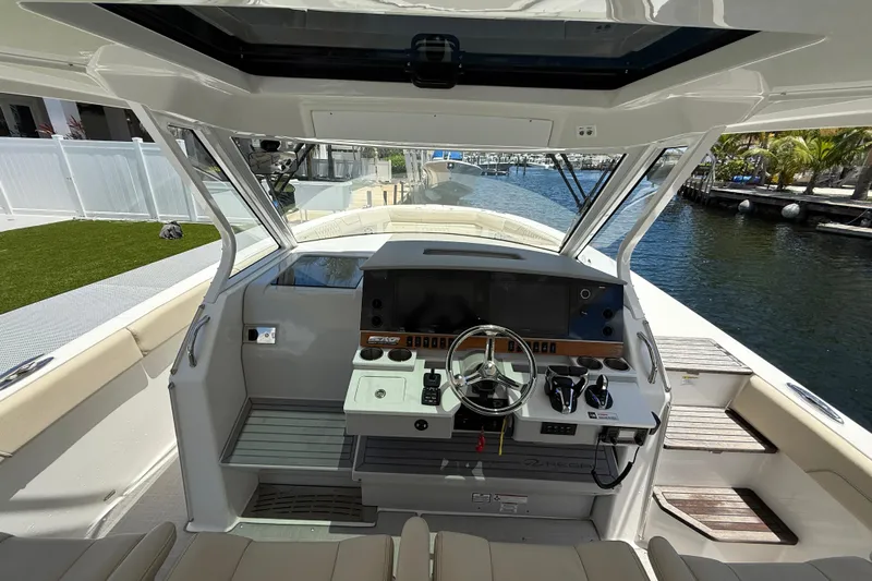  Yacht Photos Pics 2022 Regal 38 SAV boat cockpit with modern controls and waterfront view.