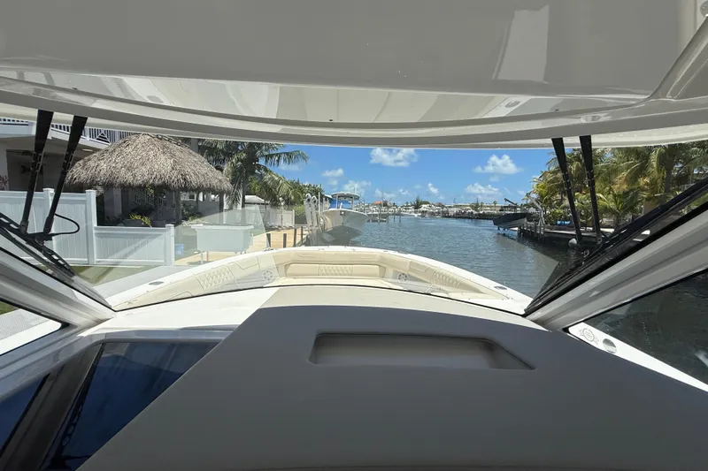  Yacht Photos Pics View from 2022 Regal 38 SAV boat, overlooking a serene canal with palm trees.