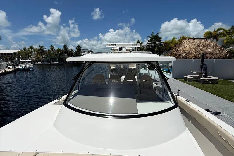  Yacht Photos Pics 2022 Regal 38 SAV boat docked by waterfront under clear blue sky.