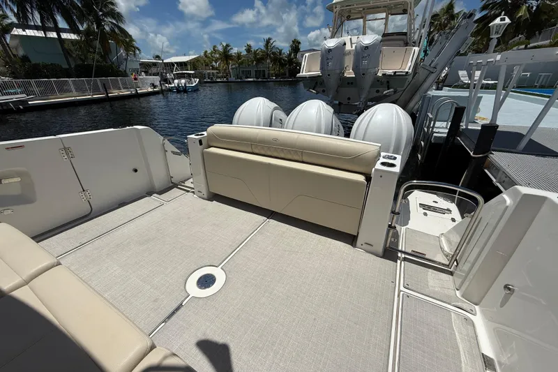  Yacht Photos Pics 2022 Regal 38 SAV boat deck with seating, docked by a waterfront.