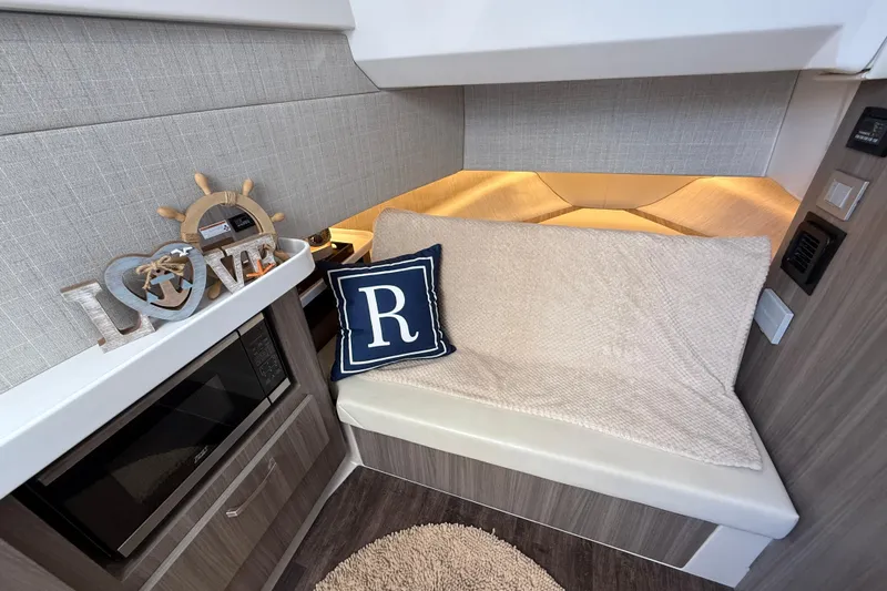  Yacht Photos Pics 2022 Regal 38 SAV interior with cozy seating, decorative pillow, and nautical decor.
