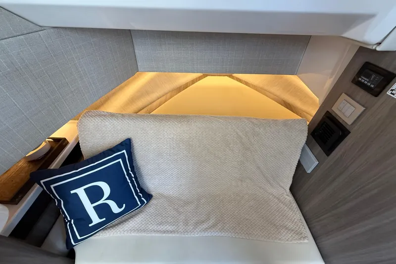  Yacht Photos Pics 2022 Regal 38 SAV cabin interior with cozy bedding and decorative pillow.