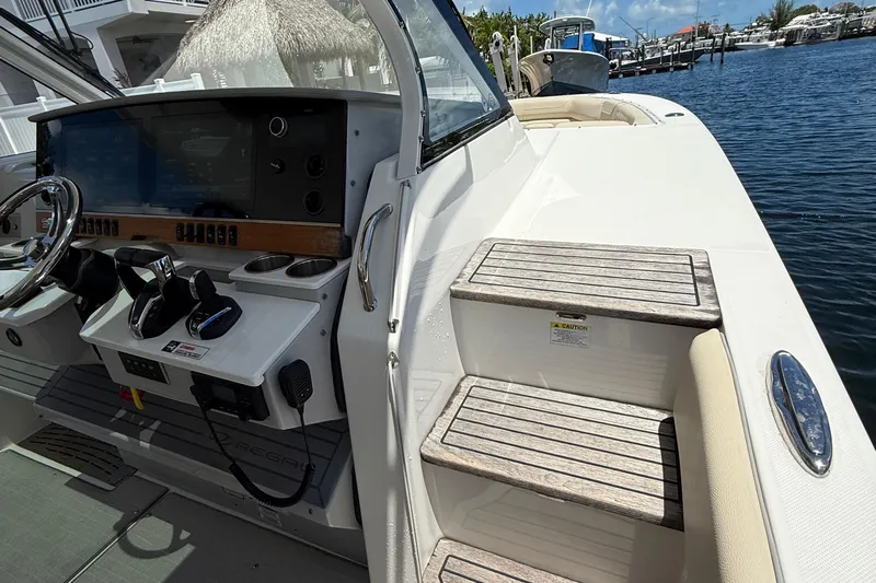  Yacht Photos Pics 2022 Regal 38 SAV boat helm with controls and steps, docked by the water.