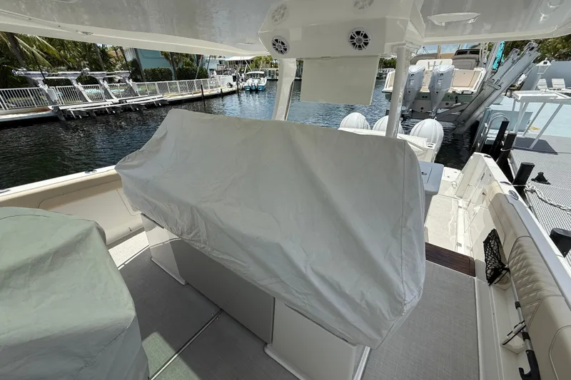  Yacht Photos Pics 2022 Regal 38 SAV boat interior with covered seating, docked by the water.