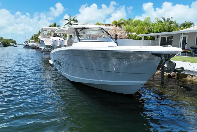  Yacht Photos Pics 2022 Regal 38 SAV boat docked on a sunny day, surrounded by palm trees.