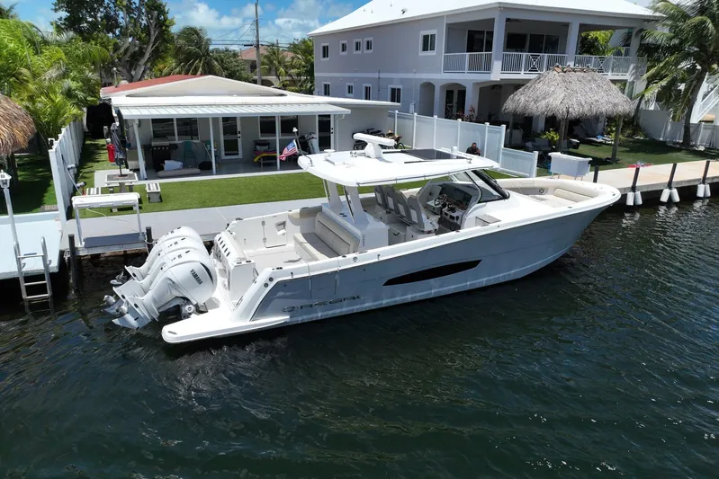  Yacht Photos Pics 2022 Regal 38 SAV boat docked by waterfront home with lush greenery.