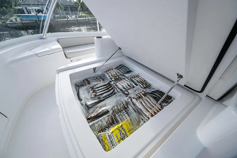 South Jersey Yacht Sales Demo Boat Yacht Photos Pics Viking 64 Convertible 2025 yacht with open storage compartment filled with packaged fish.