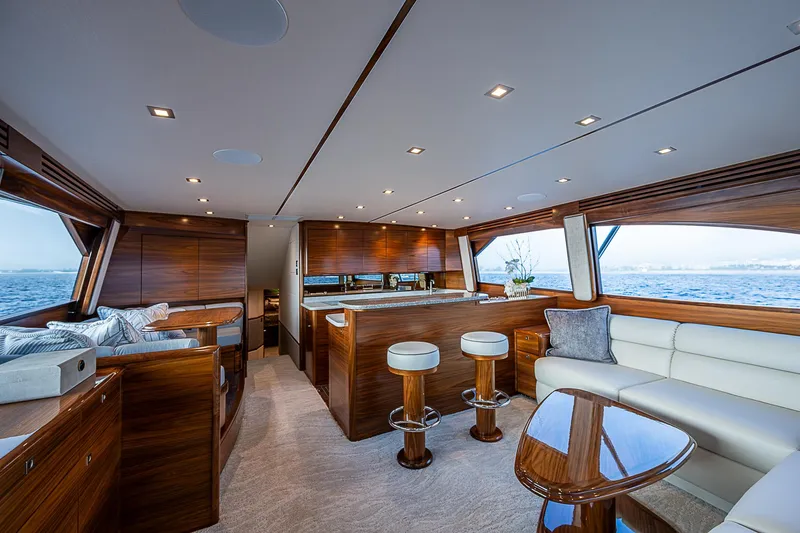South Jersey Yacht Sales Demo Boat Yacht Photos Pics Luxurious interior of 2025 Viking 64 Convertible yacht with elegant wood finishes and ocean view.