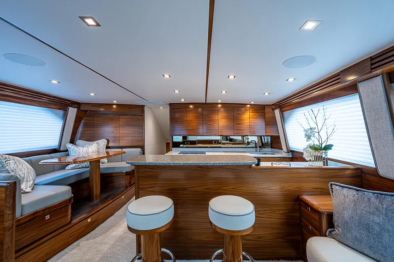 South Jersey Yacht Sales Demo Boat Yacht Photos Pics Luxurious interior of 2025 Viking 64 Convertible yacht with modern wood finishes and seating.