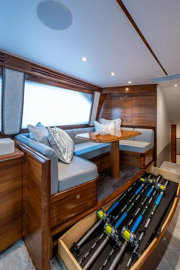 South Jersey Yacht Sales Demo Boat Yacht Photos Pics Luxurious interior of 2025 Viking 64 Convertible yacht with elegant seating and fishing rod storage.