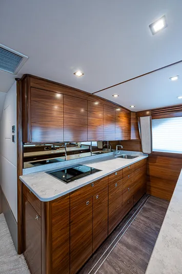 South Jersey Yacht Sales Demo Boat Yacht Photos Pics Luxurious kitchen interior of 2025 Viking 64 Convertible yacht with sleek wood cabinetry.