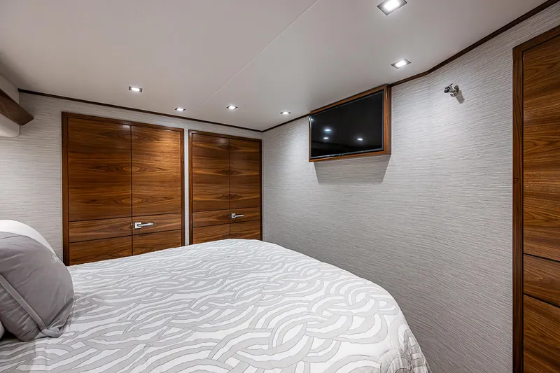 South Jersey Yacht Sales Demo Boat Yacht Photos Pics Luxurious bedroom interior of 2025 Viking 64 Convertible yacht with modern wood finishes.
