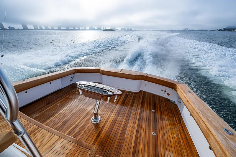 South Jersey Yacht Sales Demo Boat Yacht Photos Pics 2025 Viking 64 Convertible yacht cruising on open water, showcasing elegant wooden deck.