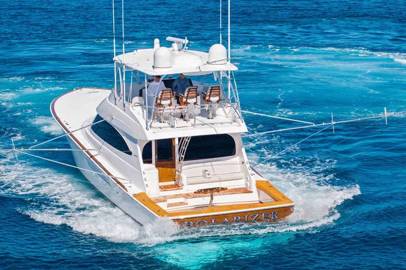  Yacht Photos Pics 2025 Viking 64 Convertible yacht cruising on clear blue ocean waters.