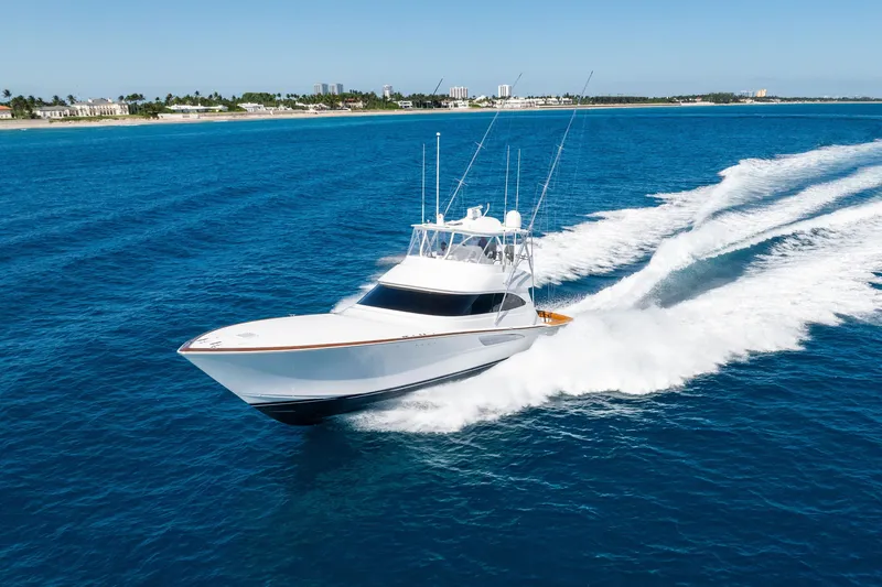  Yacht Photos Pics 2025 Viking 64 Convertible yacht cruising on open blue ocean near coastline.