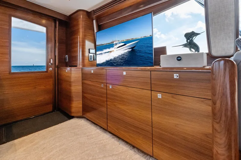  Yacht Photos Pics Luxurious interior of 2025 Viking 64 Convertible yacht with wooden cabinetry and ocean view.