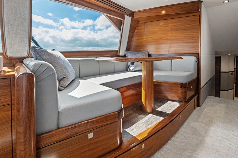  Yacht Photos Pics Luxurious interior of 2025 Viking 64 Convertible yacht with elegant wood finish and plush seating.