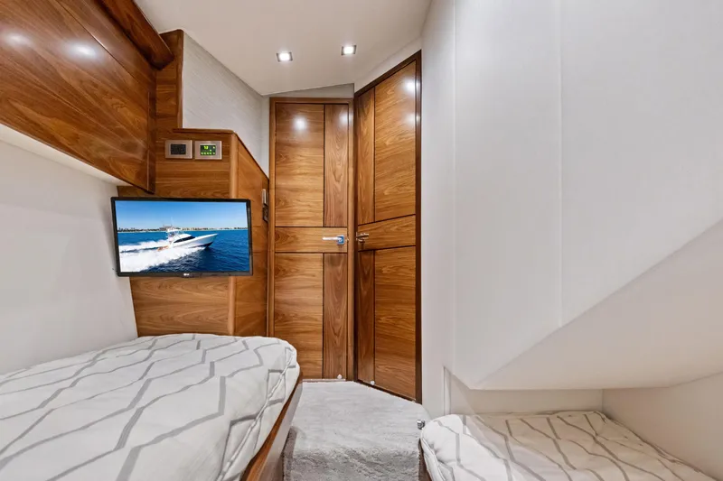  Yacht Photos Pics Luxurious cabin interior of 2025 Viking 64 Convertible yacht with wood paneling and TV.