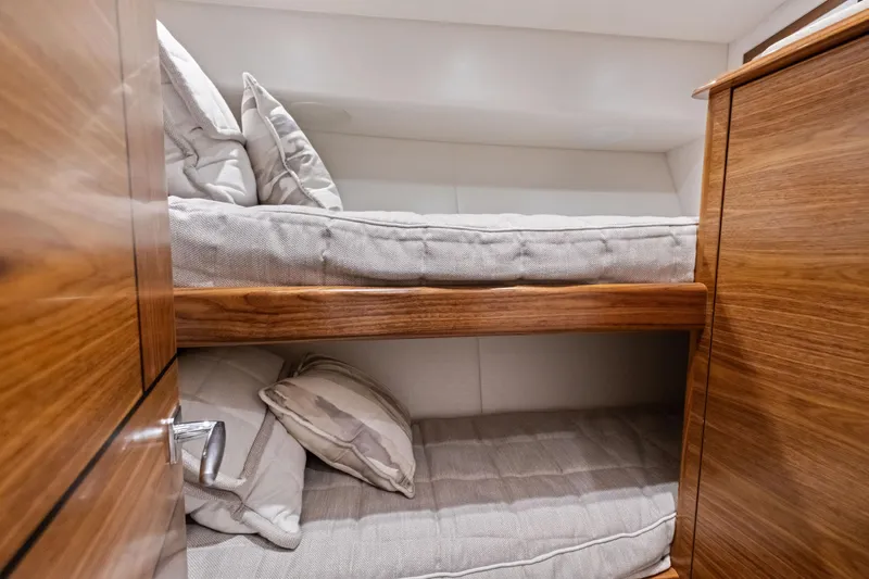  Yacht Photos Pics 2025 Viking 64 Convertible yacht interior with cozy wooden bunk beds.
