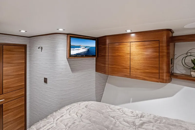  Yacht Photos Pics Luxurious interior of 2025 Viking 64 Convertible yacht with wood cabinetry and mounted TV.